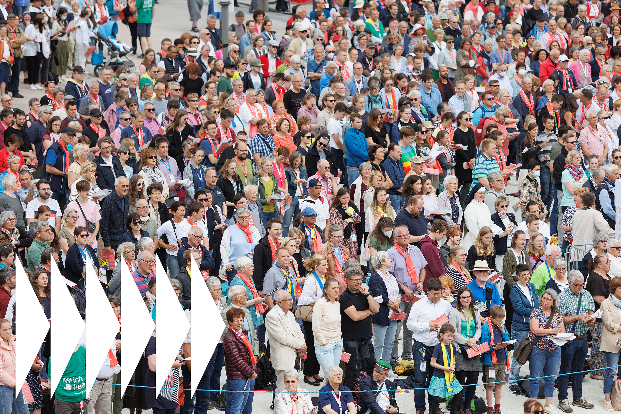 Ein Bild voll mit hunderten Menschen mit Liederzettel und Katholikentags-Schals 